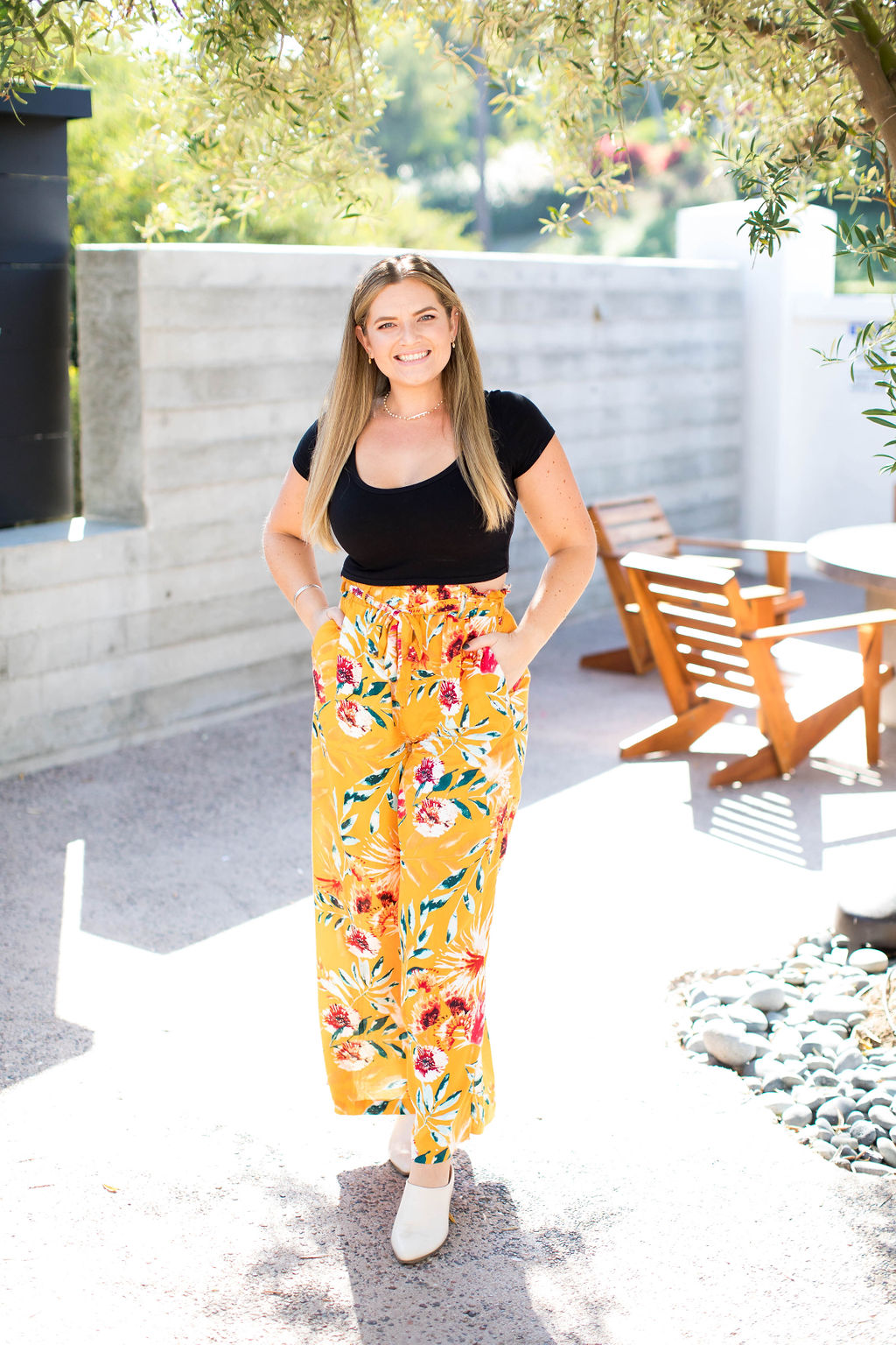 Girl standing with yellow floral pants in backyard smiling