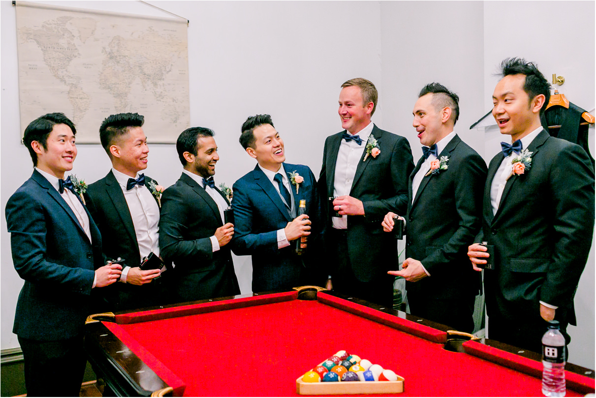 Groom with his groomsmen at pool table drinking and laughing