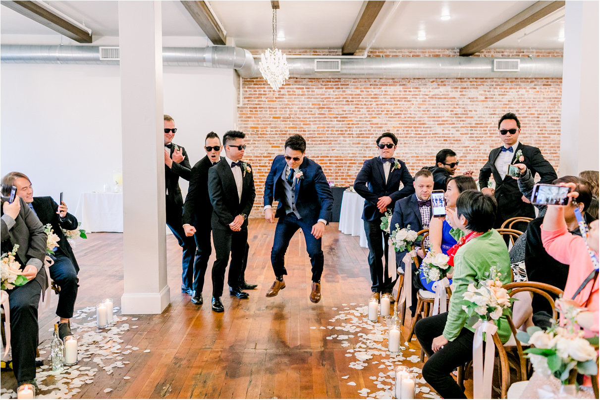 groom entering wedding ceremony by jumping over groomsmen in sunglasses