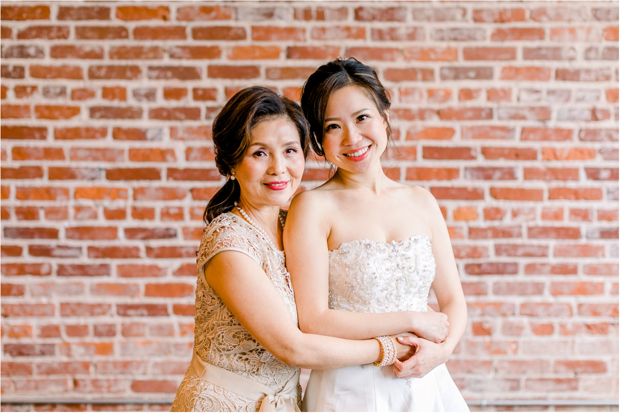 mom and daughter smiling at the camera on wedding day