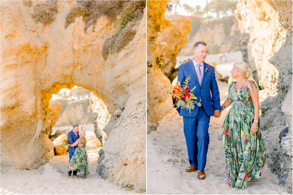 Couple under tall arch rock at beach walking towards camera