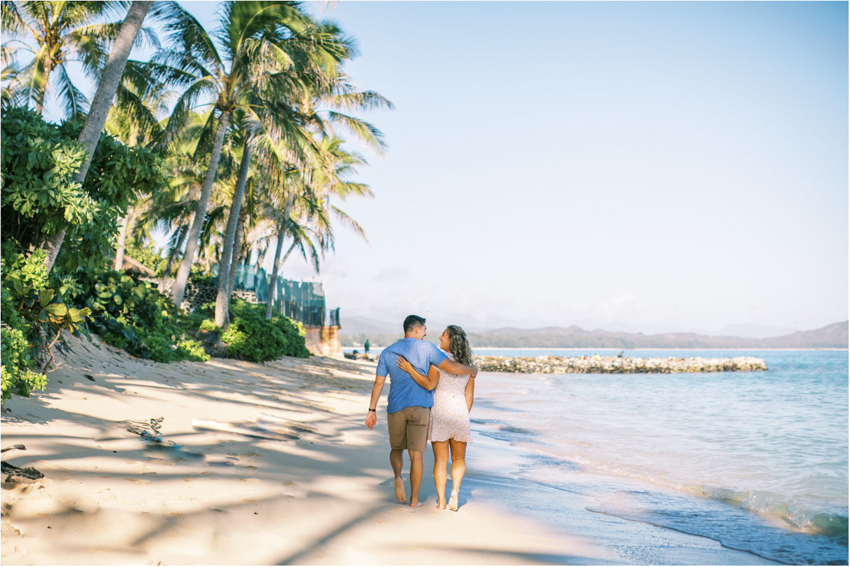 landscape image of couple walking away from camera at the beach in hawaii