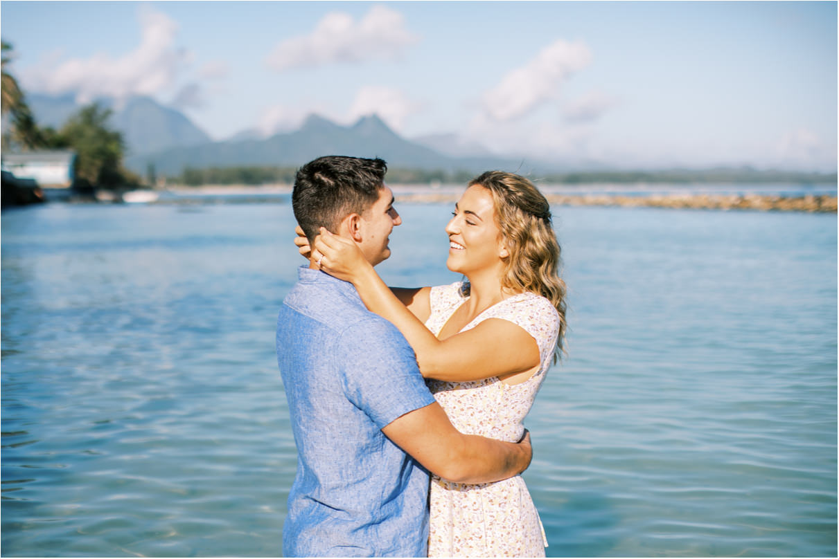 Couple facing each other at the beach with blue water