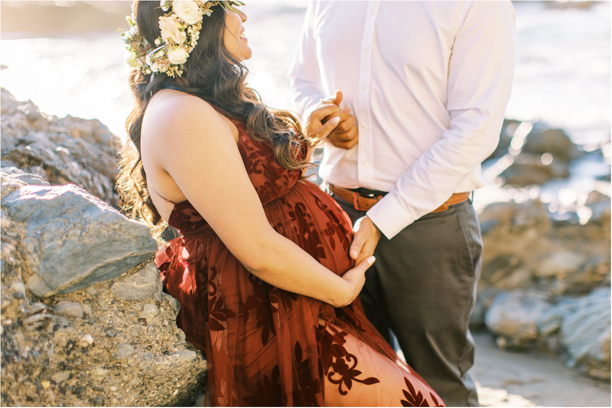 Pregnant woman sitting down and husband holding belly