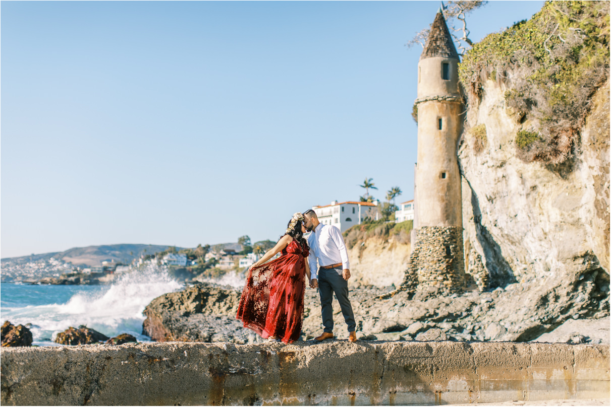 Couple kissing at beach in front of castle tower