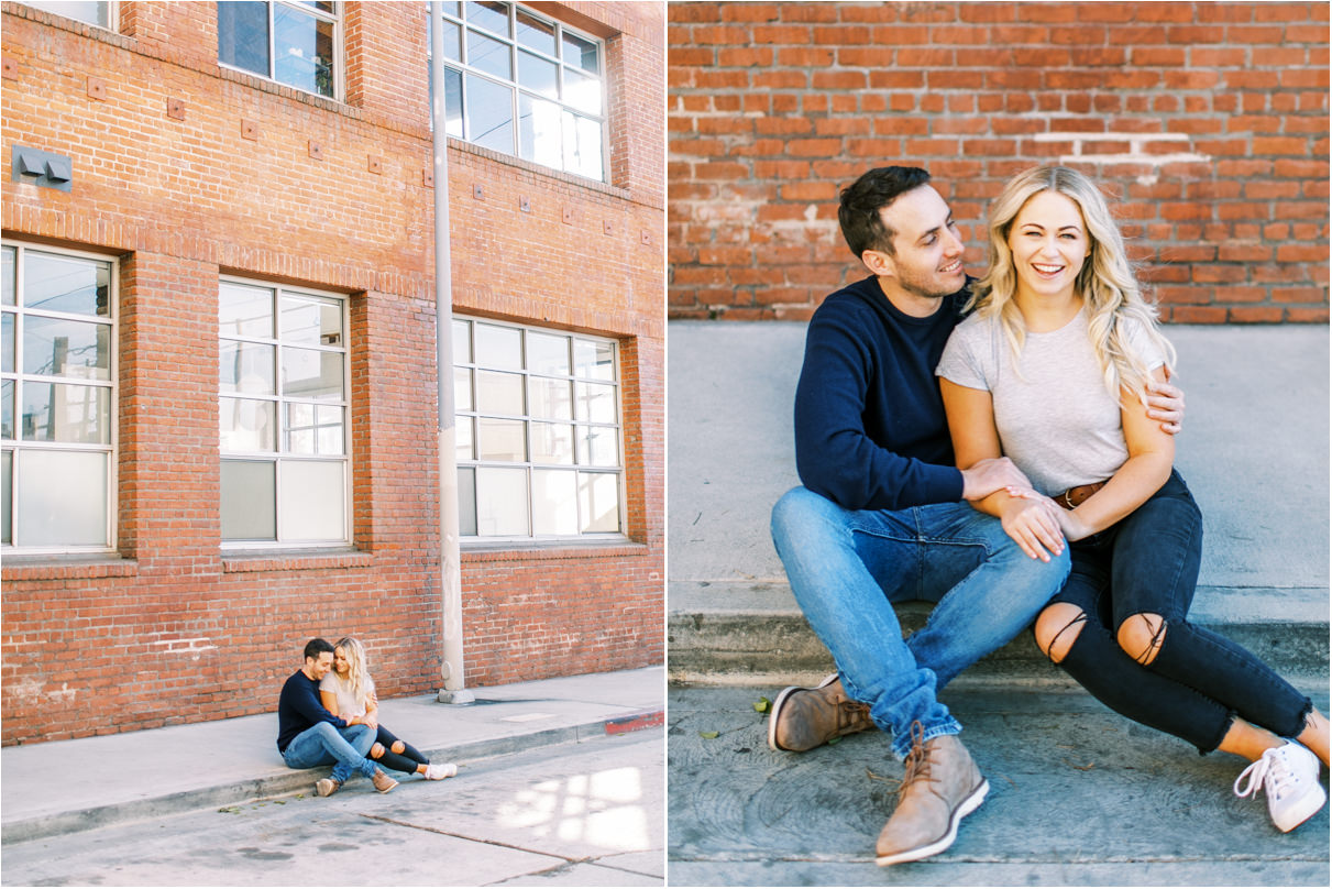 couple sitting in front of tall brick building smiling in los angeles