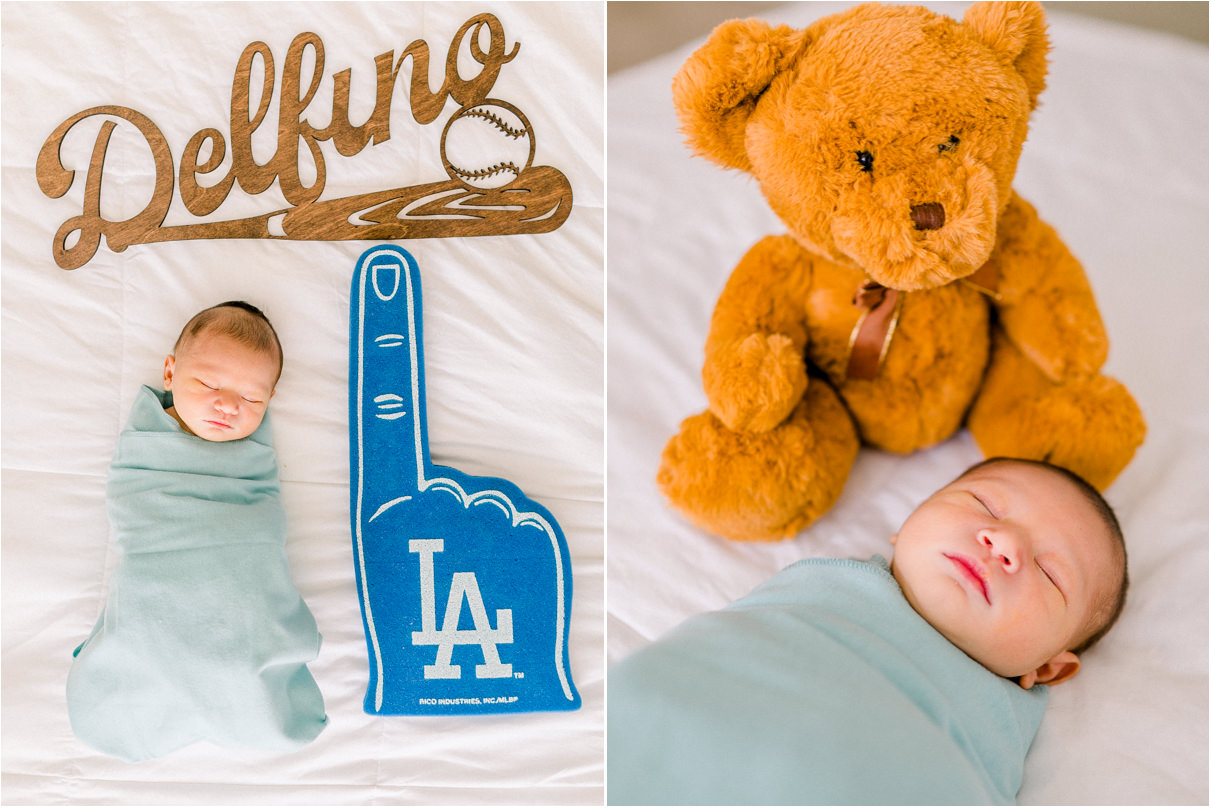 Baby boy sleeping in swaddle next to LA Dodgers foam finger and teddy bear