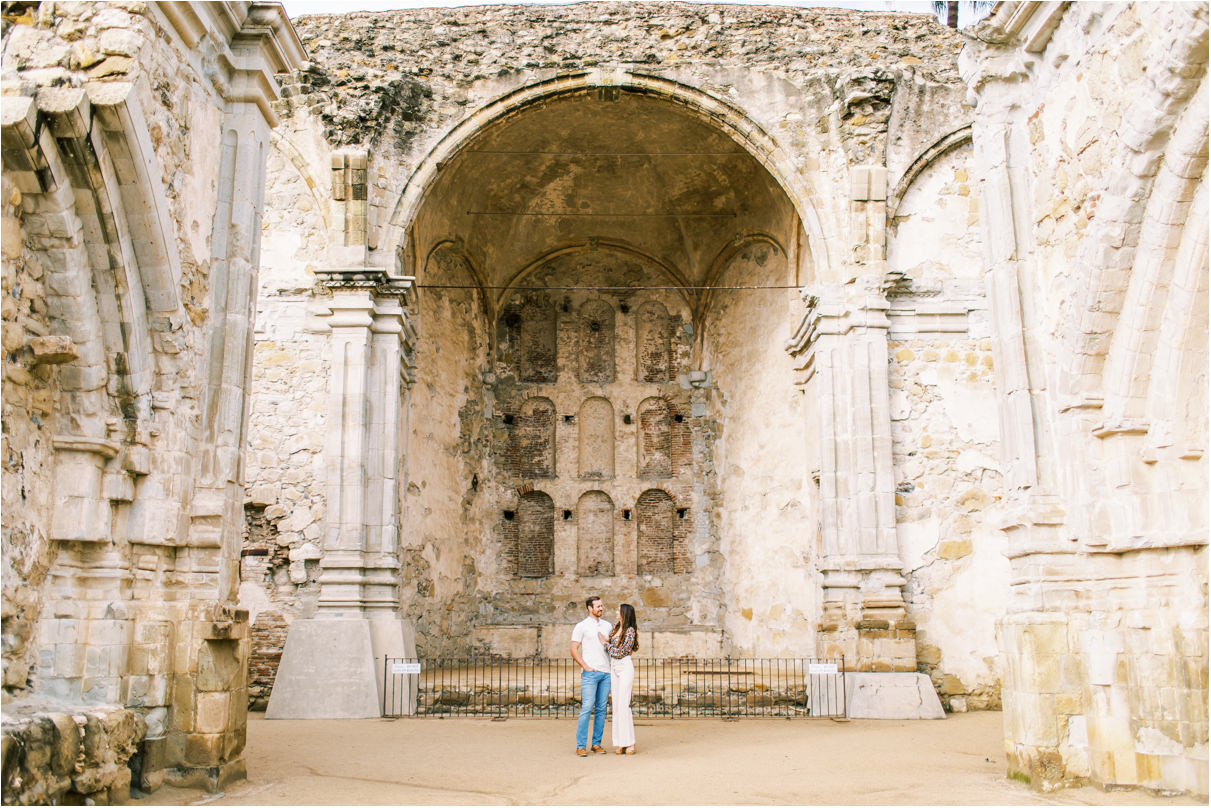 Couple in front of very tall ruin archway
