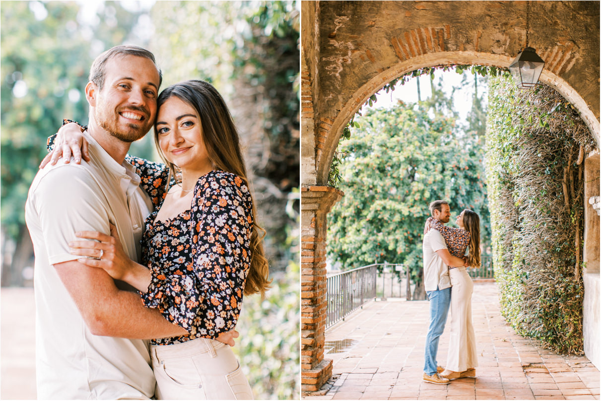 Couple standing under tall brick arch and looking at camera smiling