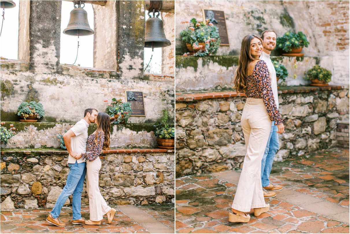Couple walking and kissing under large church bells