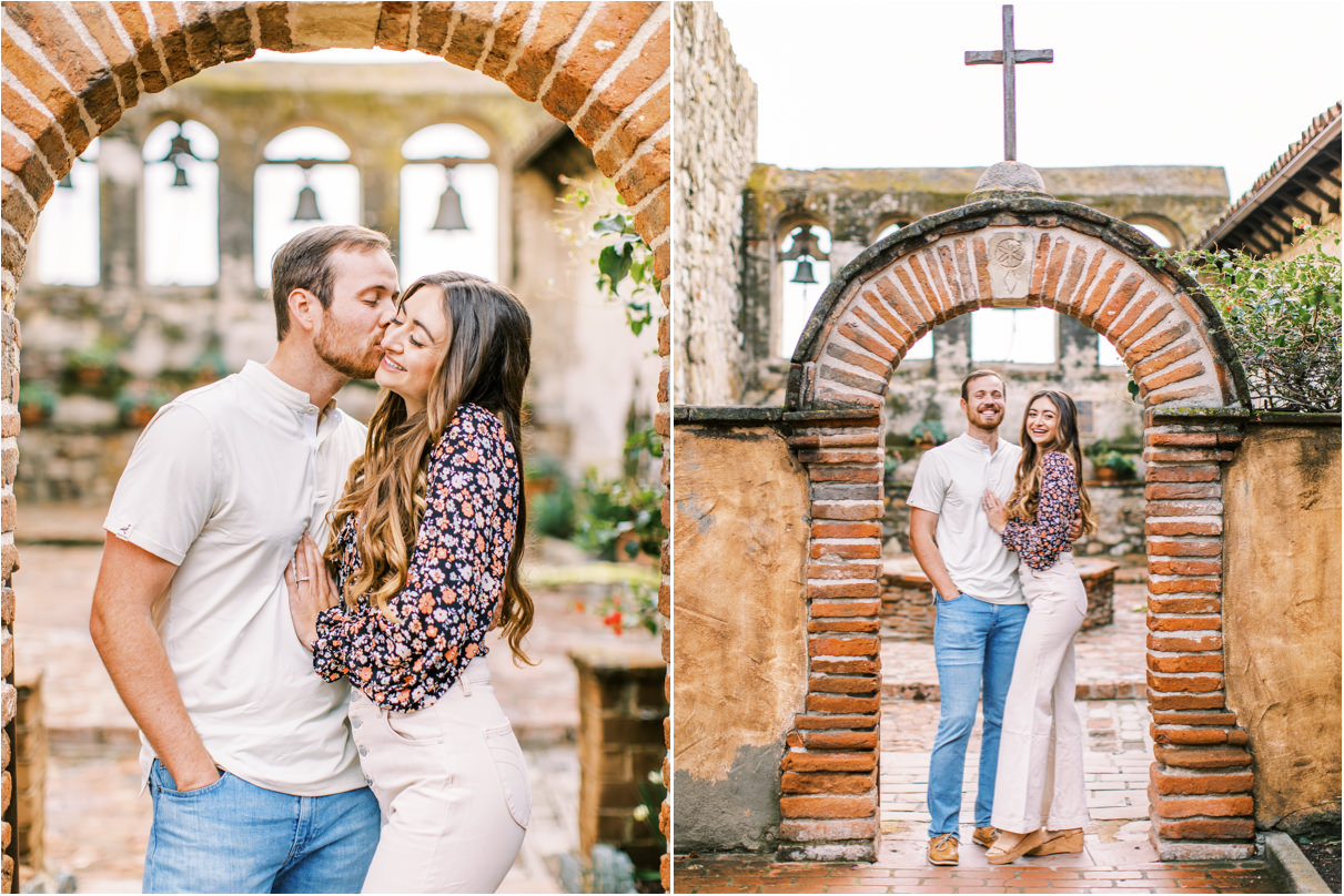 Couple standing under church brick archway with bells in the background