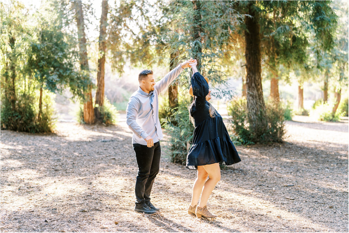 Couple dancing and spinning in a forest