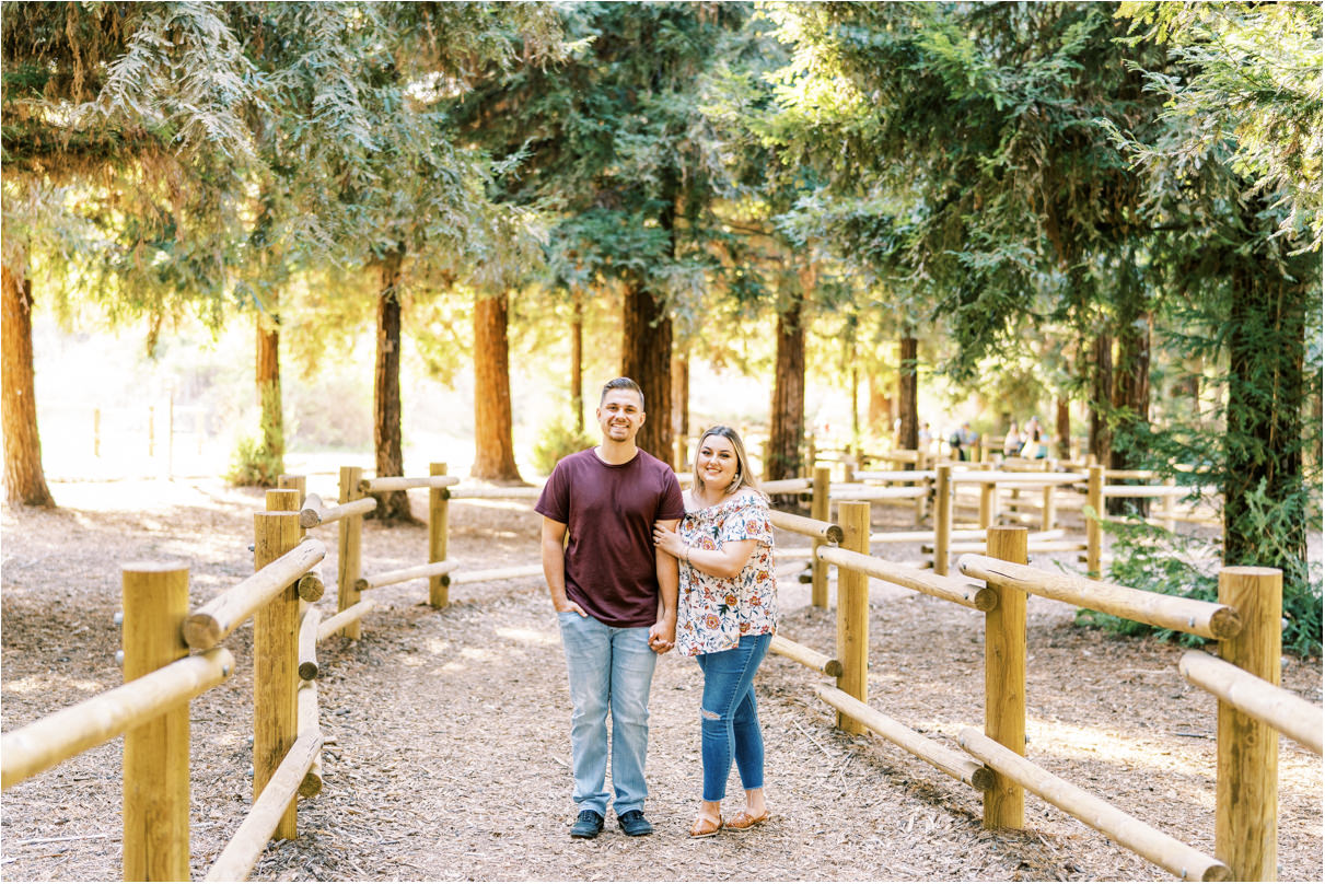 Couple standing next to each other in pathway in a forest
