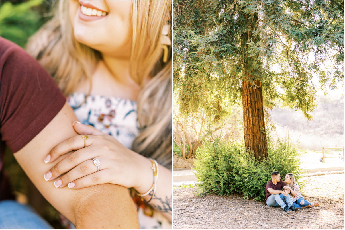 Couple smiling at each other while sitting on forest floor