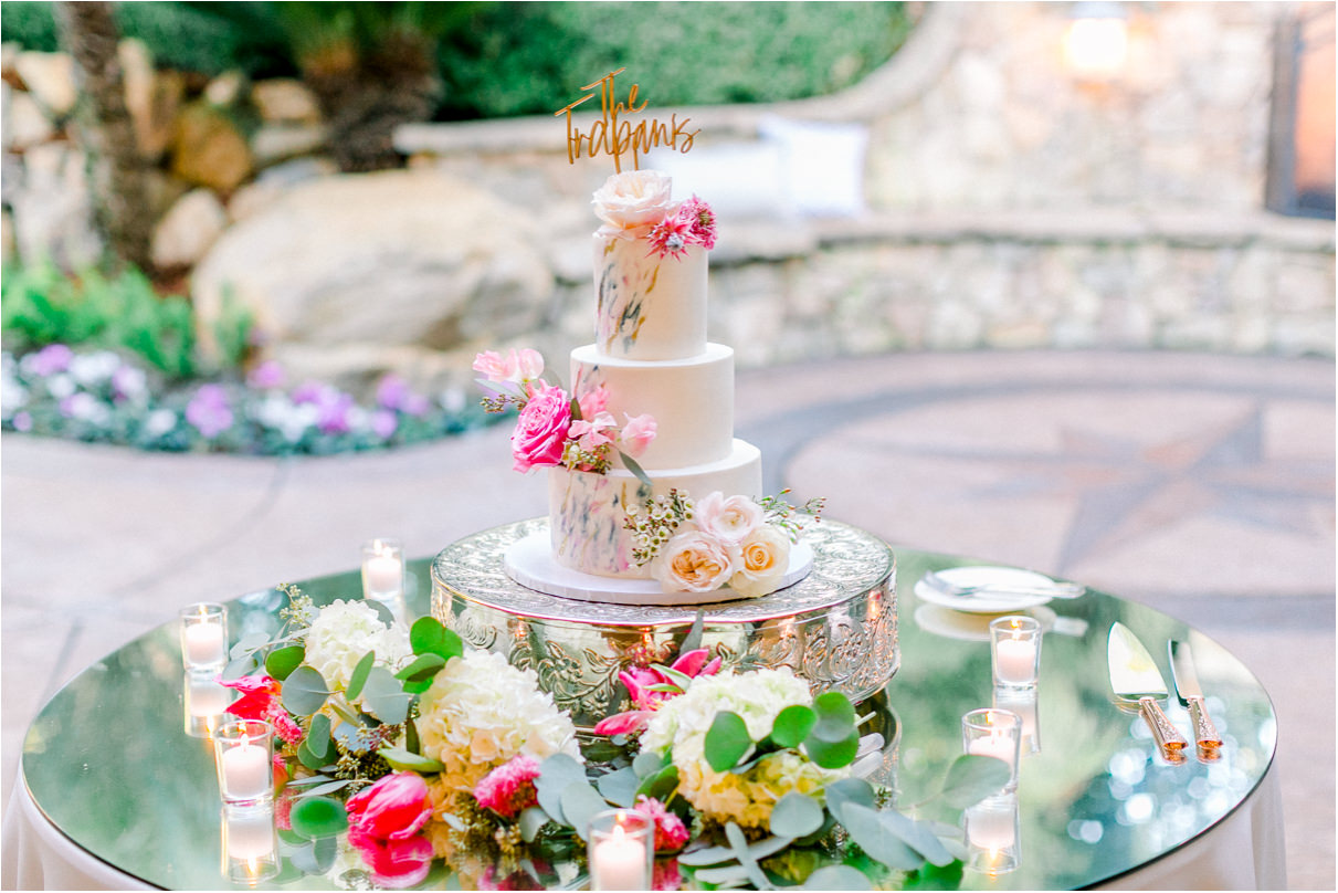 Floral wedding cake with The Trapanis wedding topper