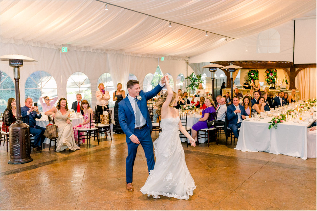 Wedding reception with groom twirling bride on the dance floor