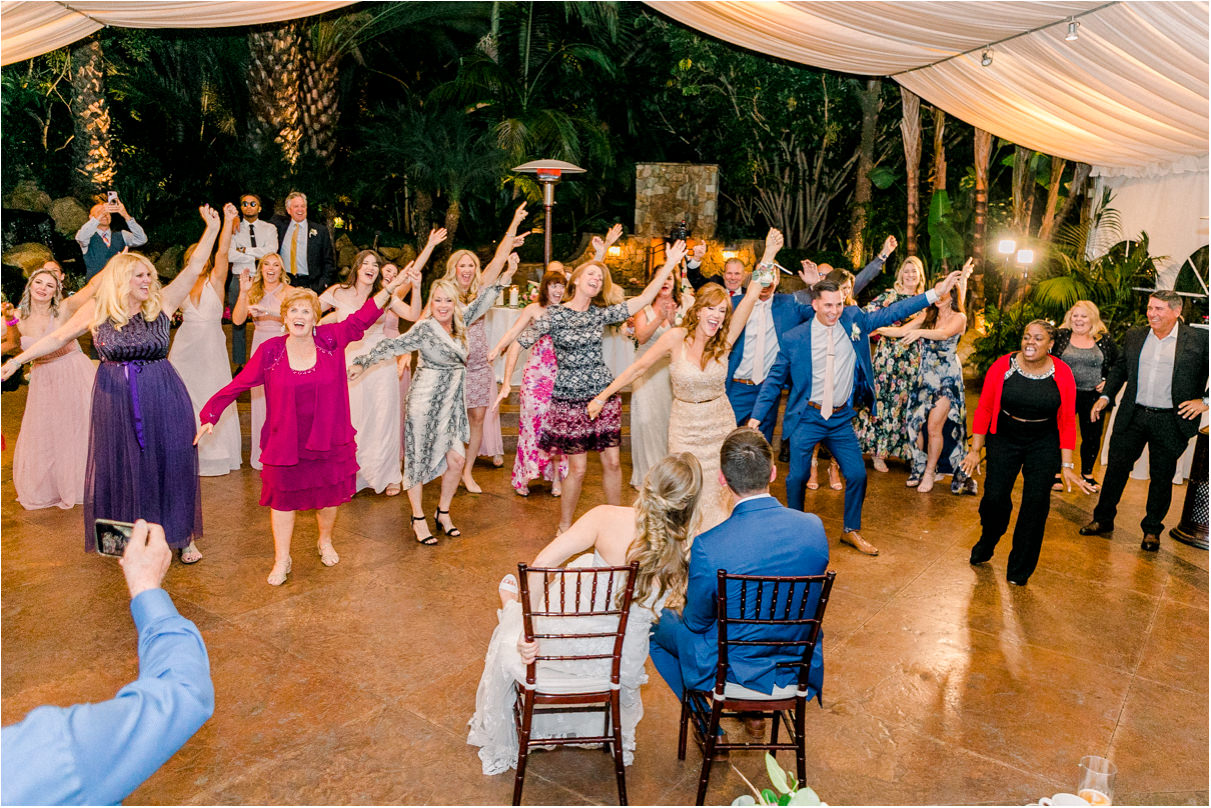 Wedding reception with couple sitting in chair as entire dance floor has dance mob to ABBA song