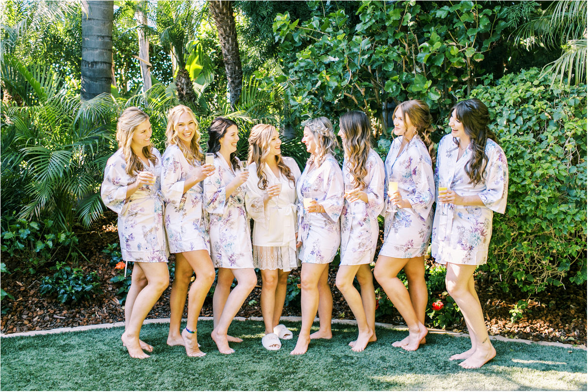 Bridal party outside in floral robes holding mimosas 