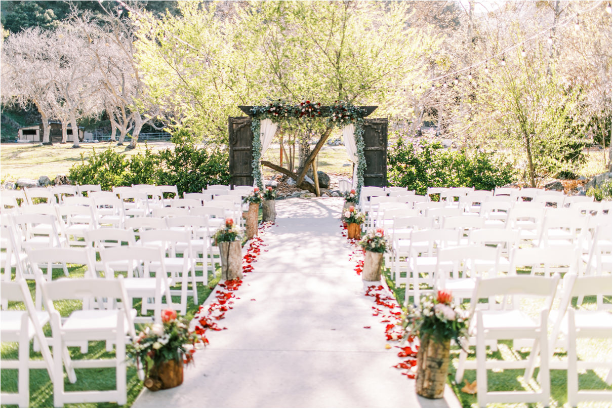 Rustic outdoor wedding ceremony with rose petals
