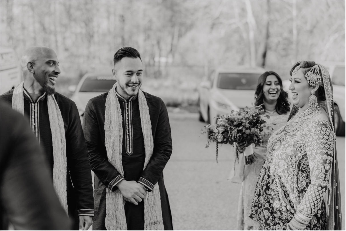Bride laughing with groomsmen after wedding ceremony