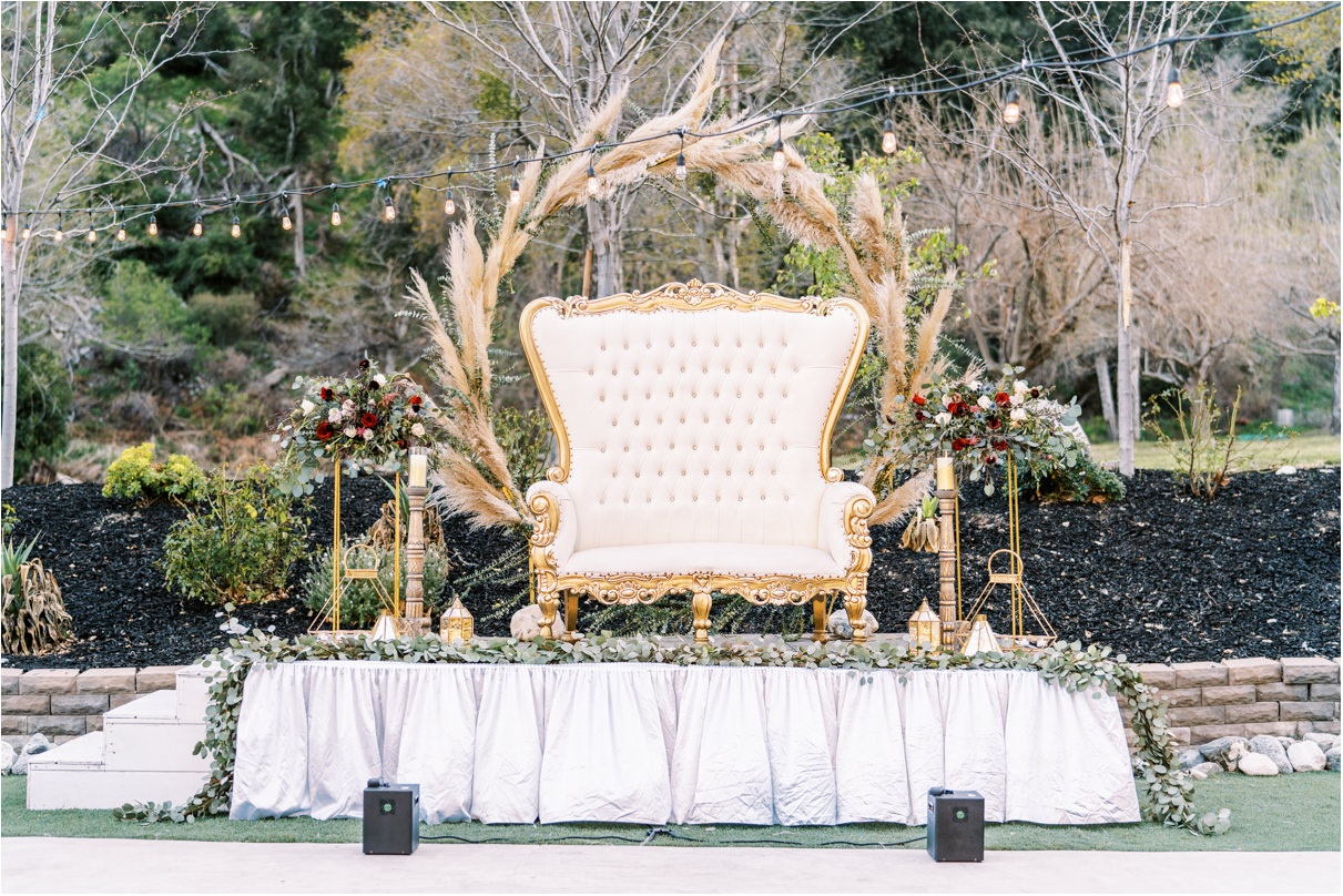Wedding reception stage with large couch and pampas grass arch