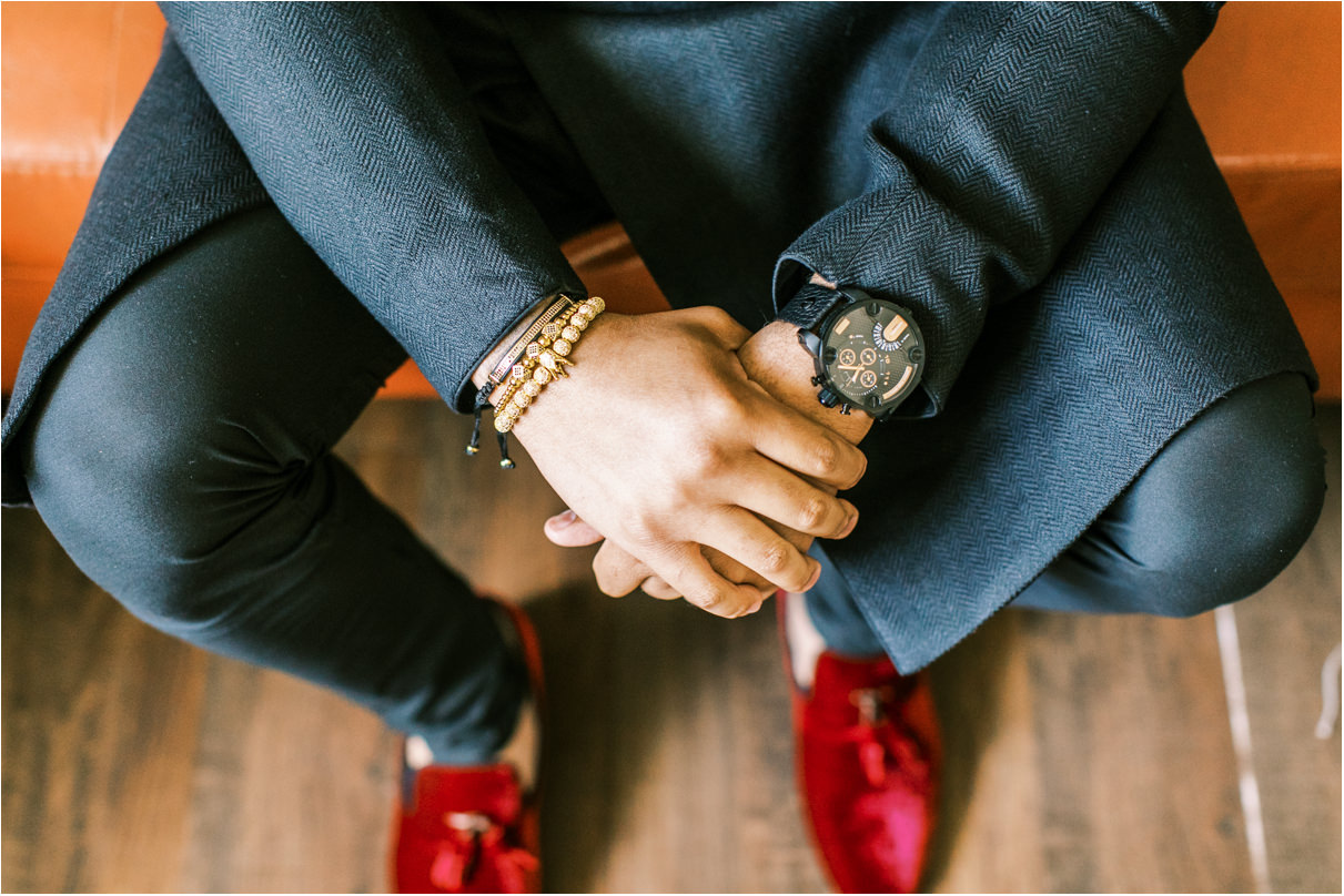 closeup of groom's watch and red velvet shoes