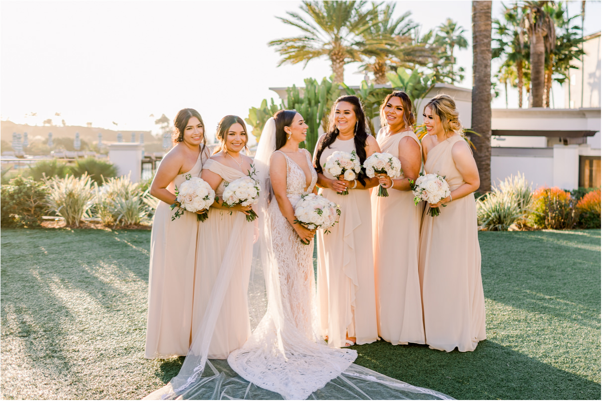 Bride laughing with her bridesmaids at sunset