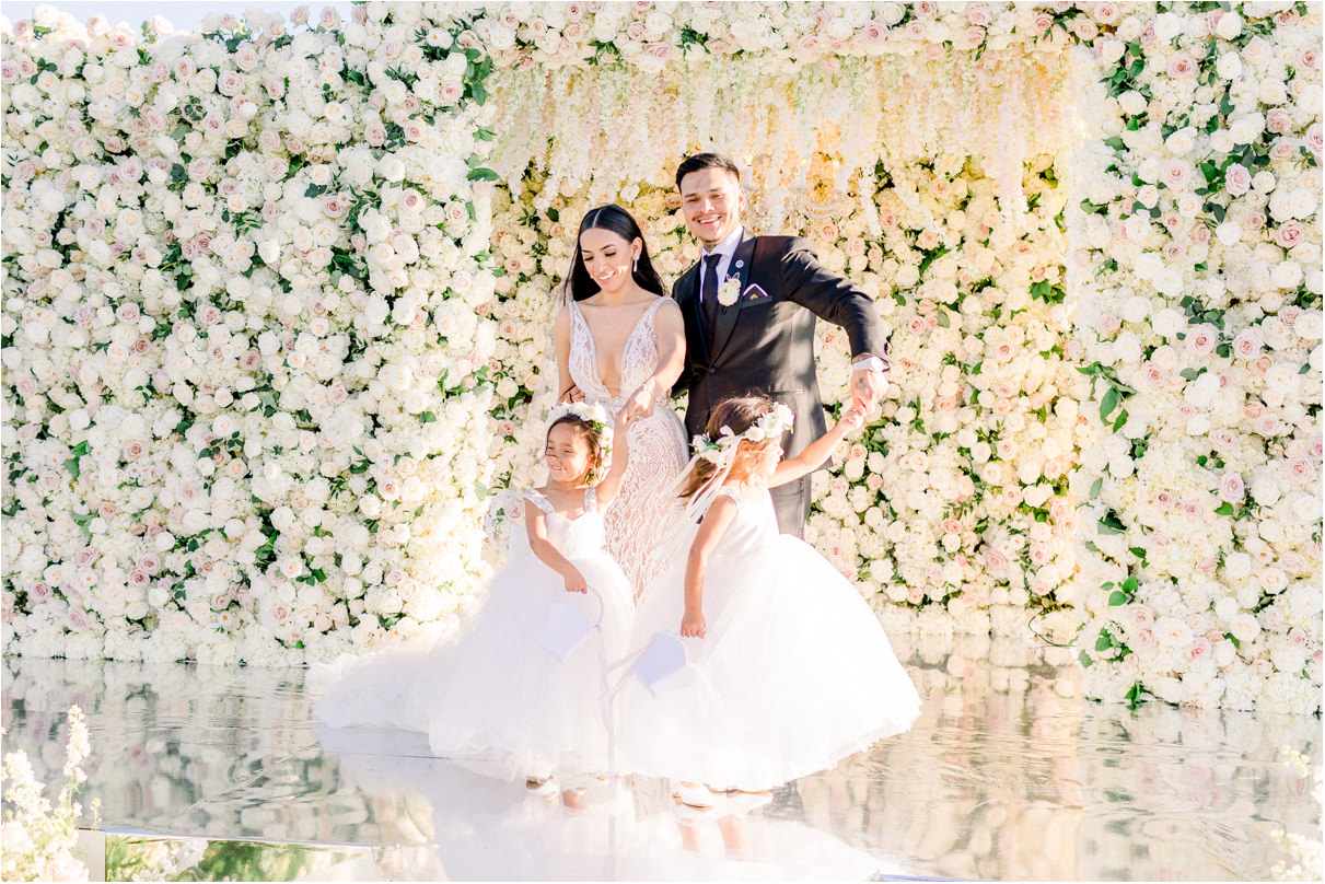 Bride and groom twirling their two daughters on wedding ceremony stage