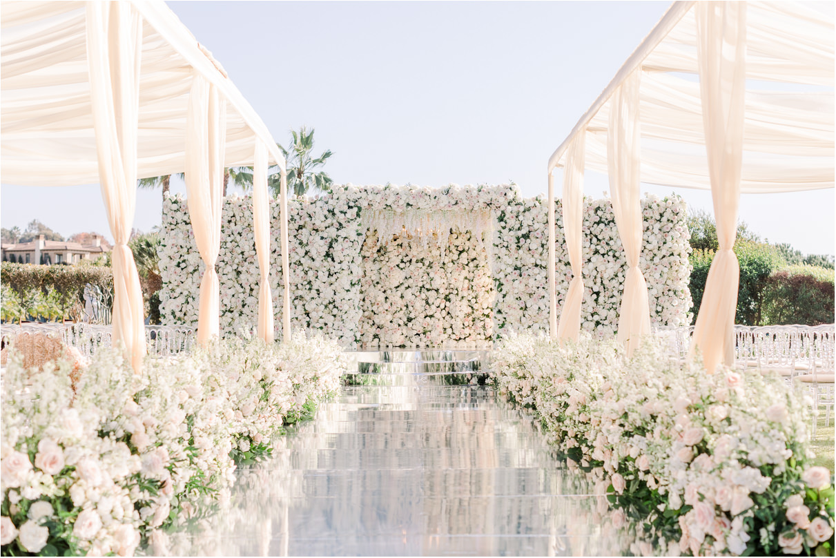 Luxury wedding ceremony with mirror aisle and rose backdrop
