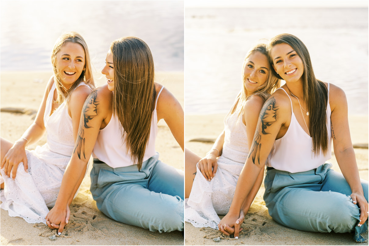 Lesbian couple in hawaii sitting in sand holding hands