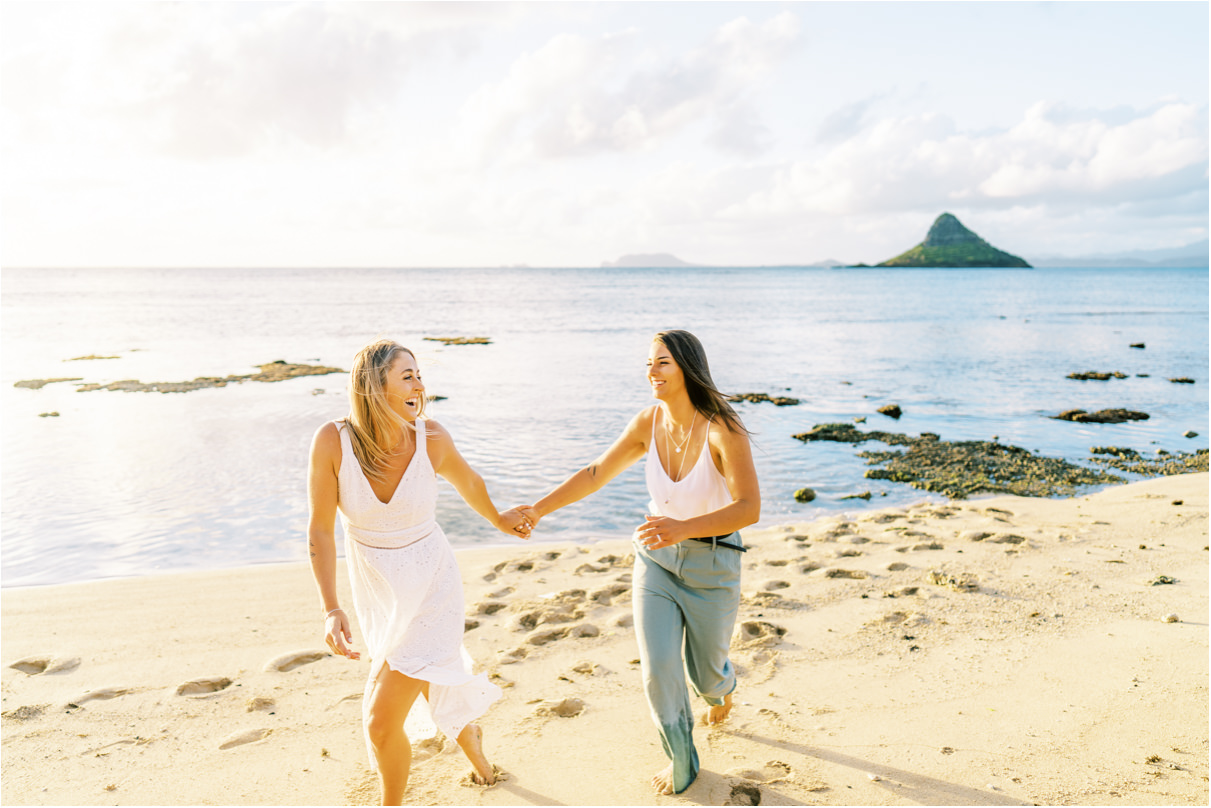 Lesbian couple in hawaii running on beach