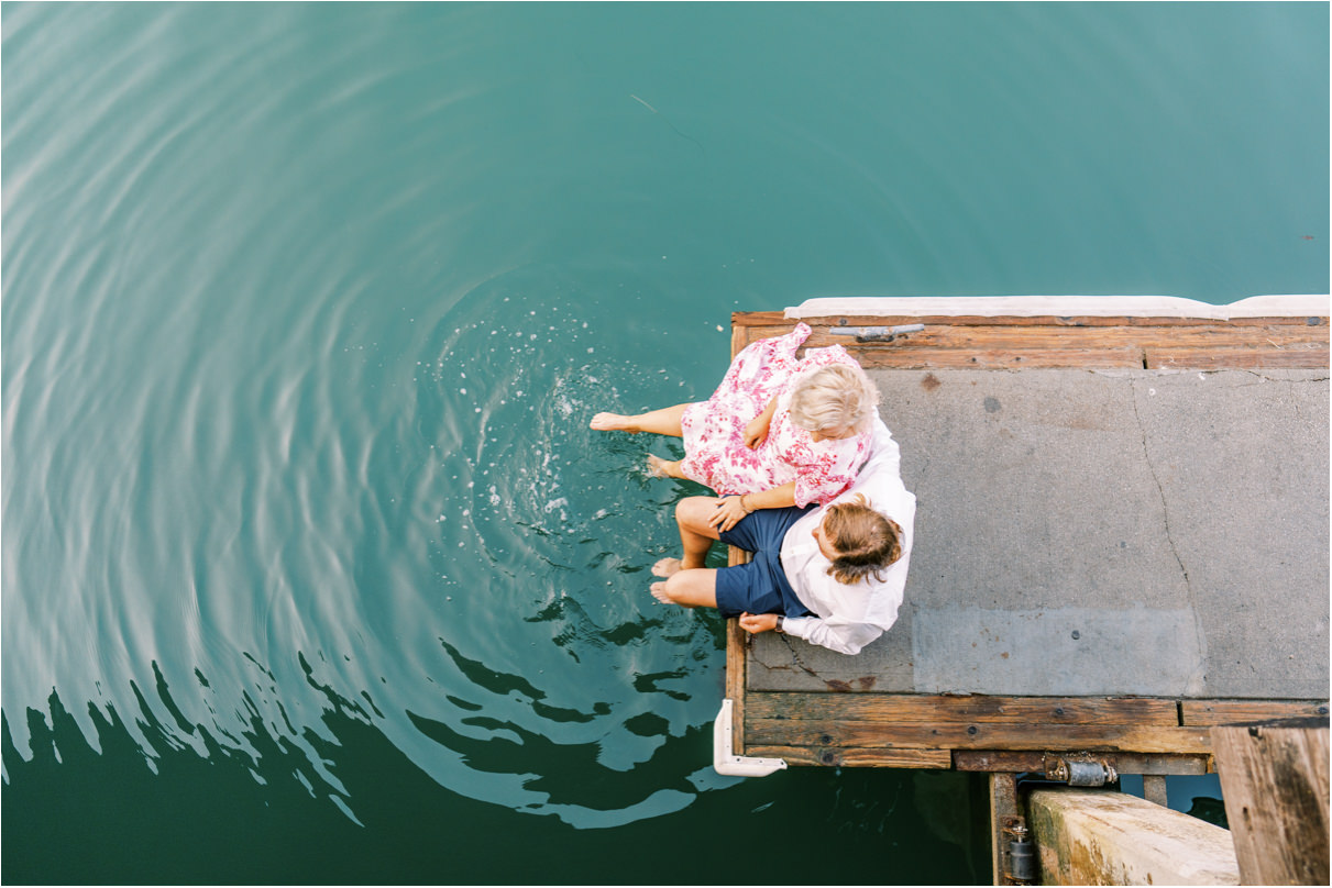 Couple sitting on dock with feet in the water