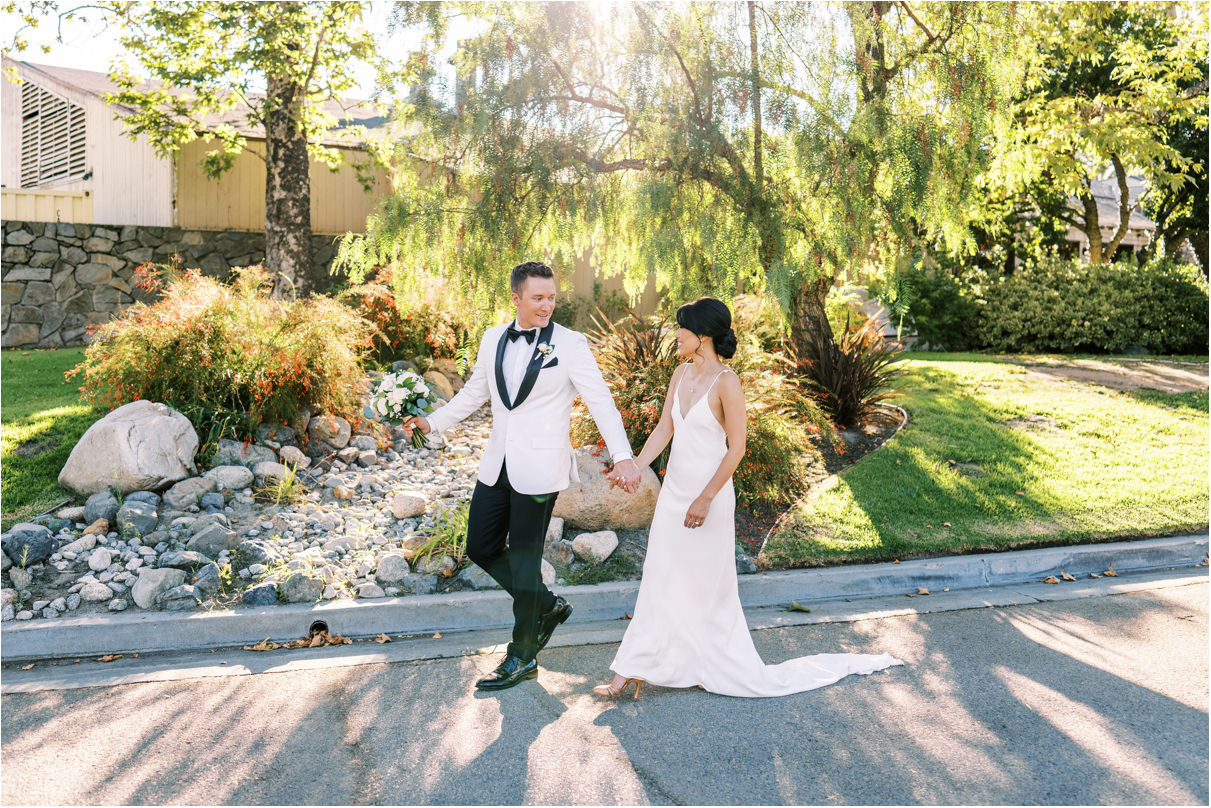 Bride and groom walking with sunlight behind them