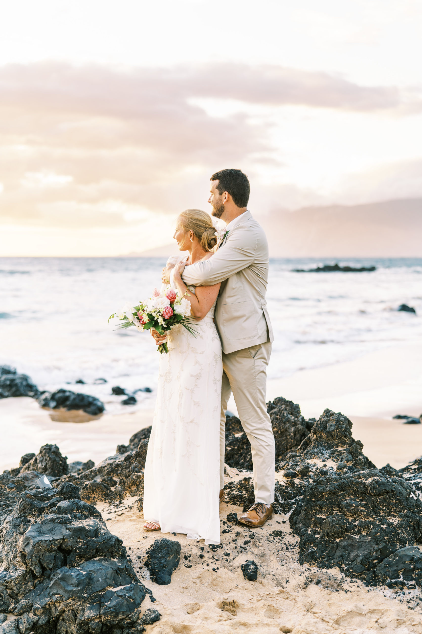 Bride and groom watching sunset at Maui beach