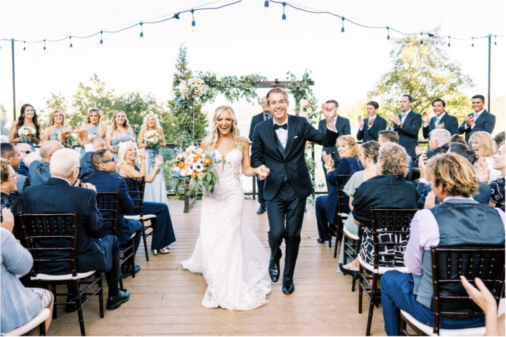 Bride and groom walking down aisle holding hands