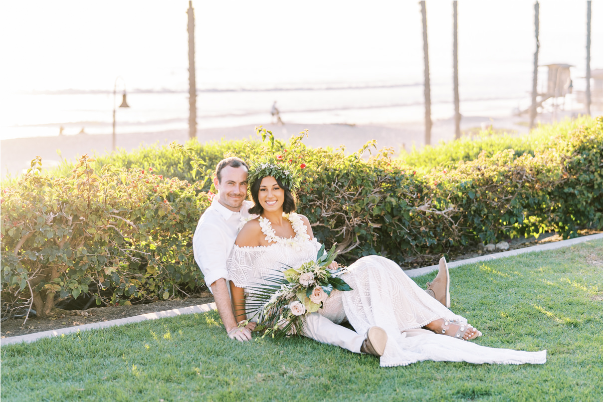 Bride and groom sitting on the grass after San Clemente wedding