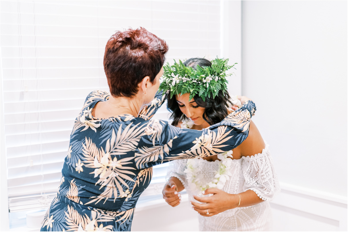 Mother of the bride helping put on lei