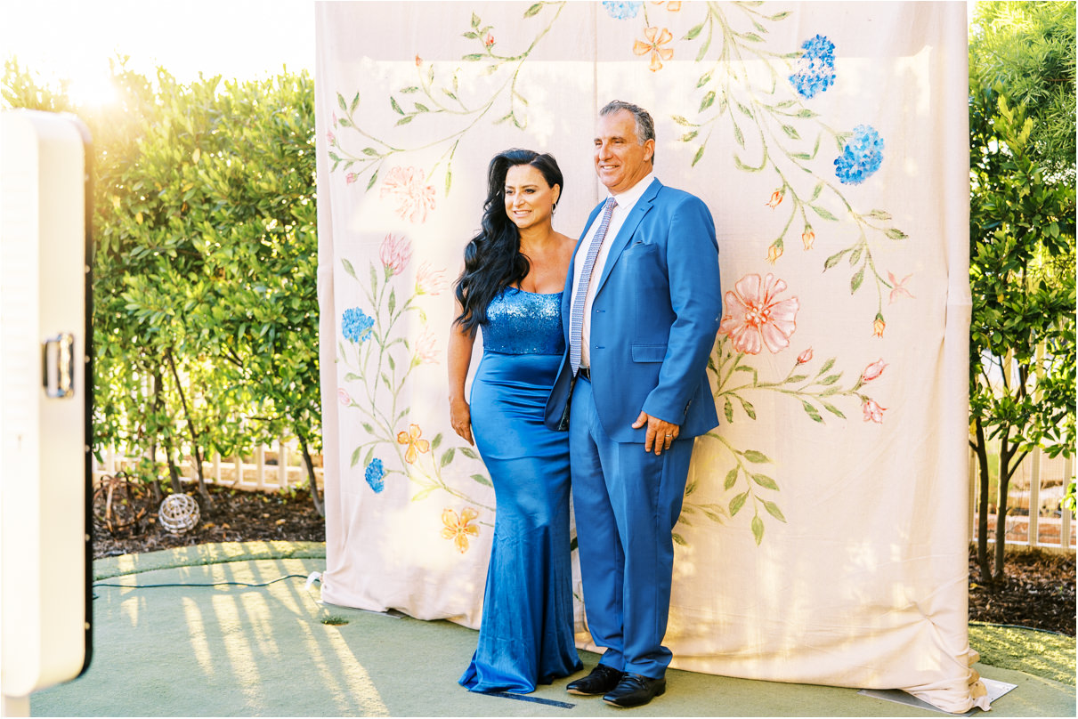 wedding guests wearing matching blue outfits taking photo booth picture