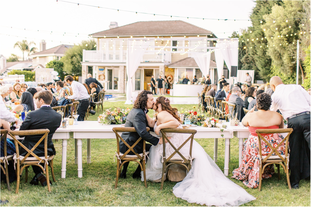 Bride and groom kissing at backyard wedding reception