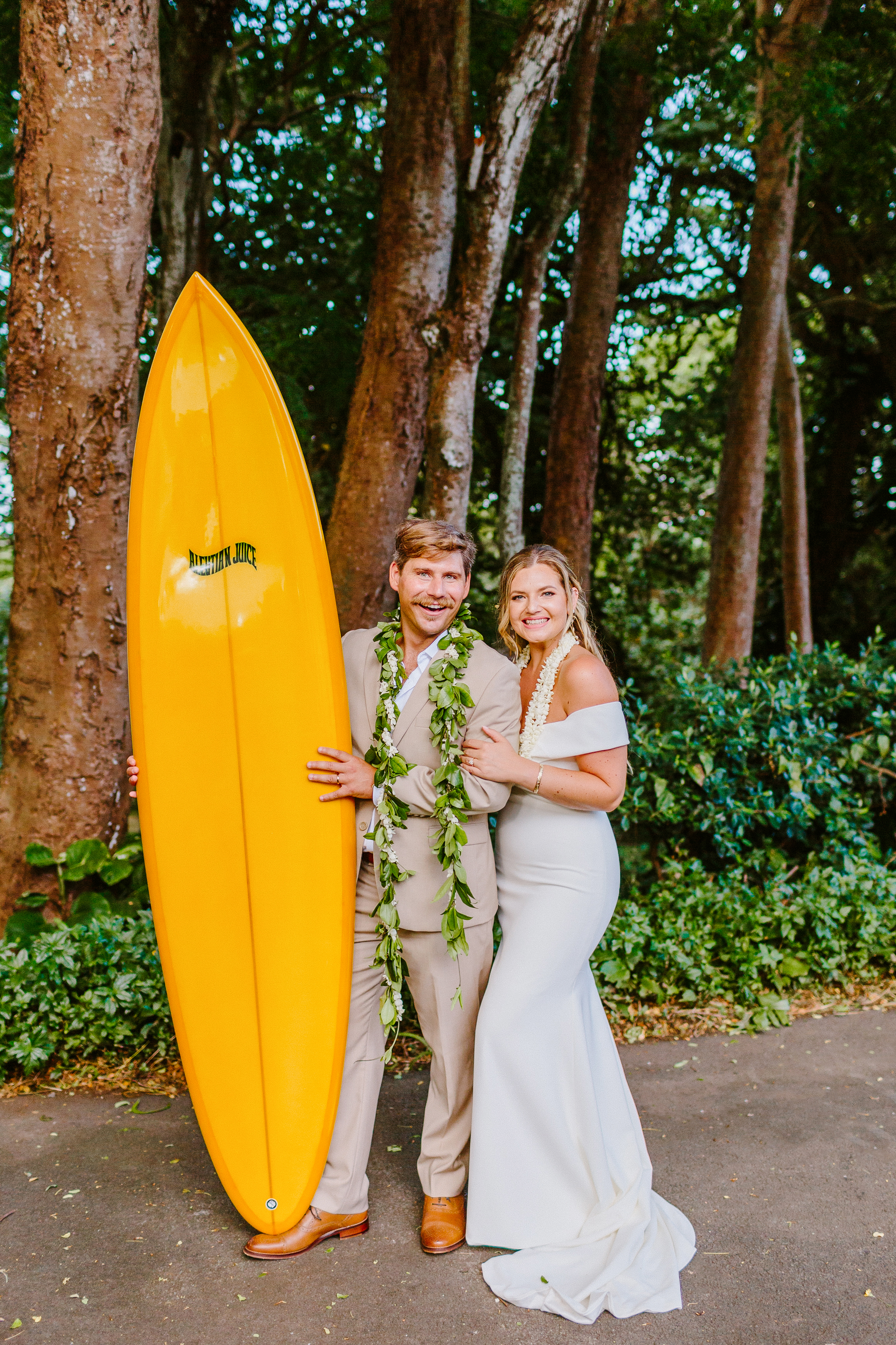 Bride and groom with yellow surfboard