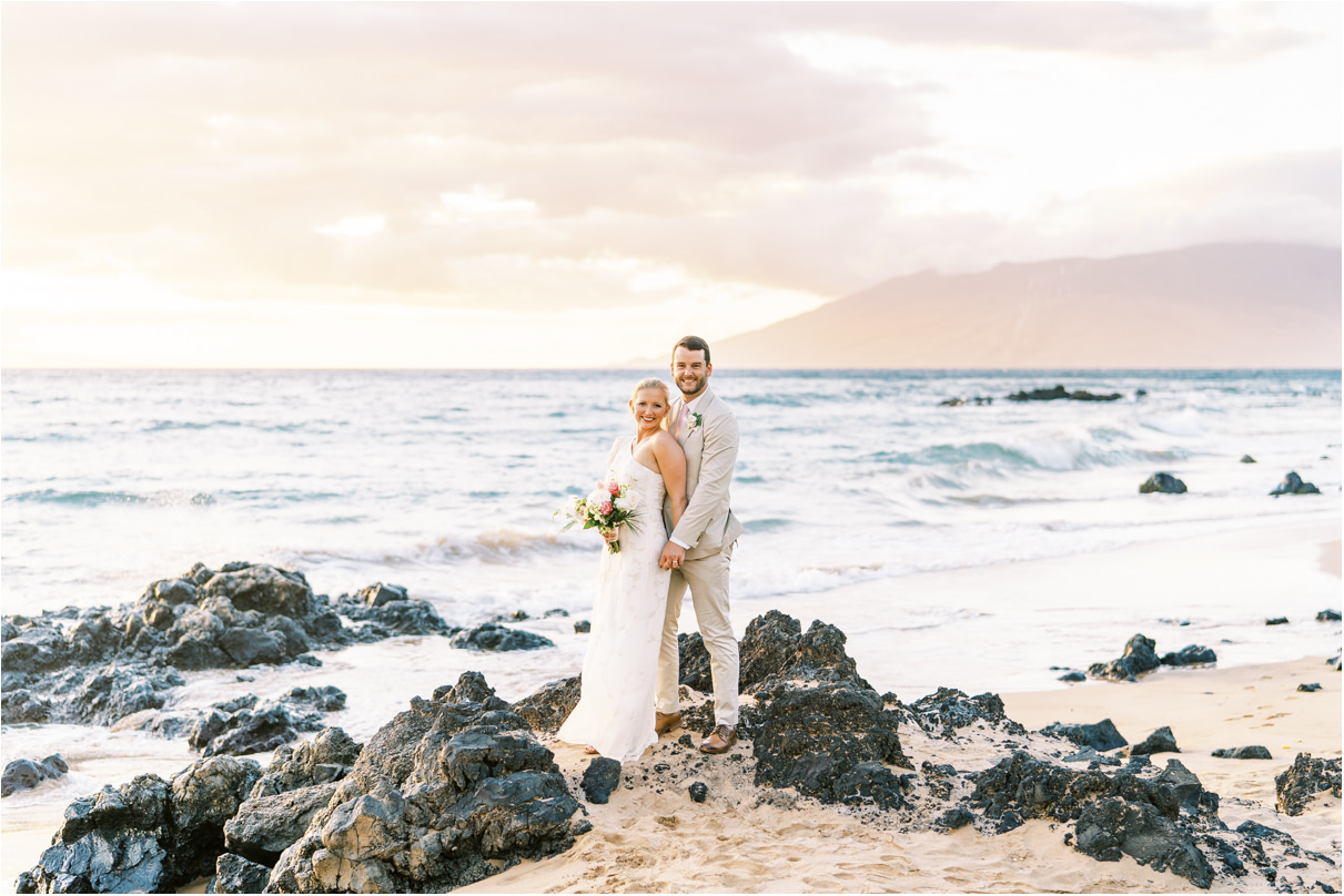 bride and groom on lava rocks on Maui beach