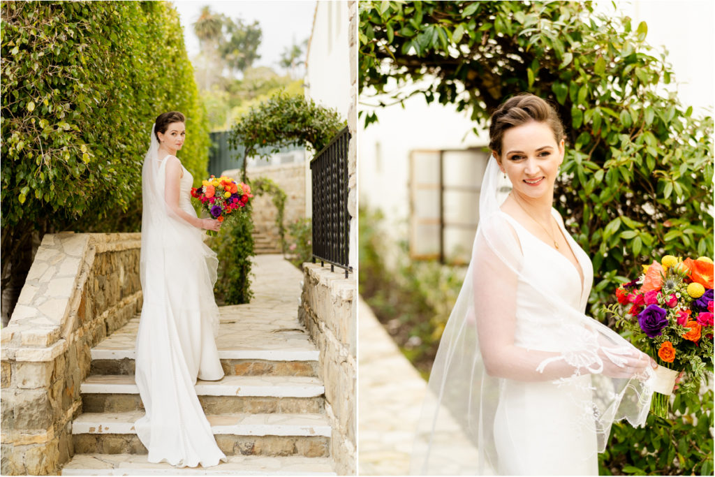 bride on stone steps in garden holding colorful flower bouquet