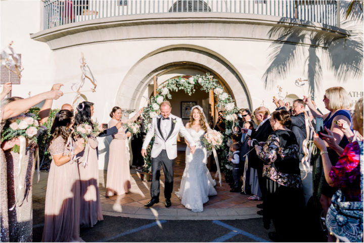 bride and groom walking outside of catholic church